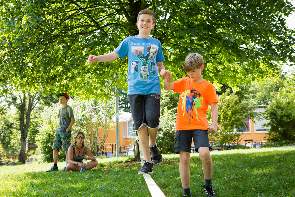 Ein Schüler balanciert auf einer Slackline: Sport im Ferien-Lerncamp
